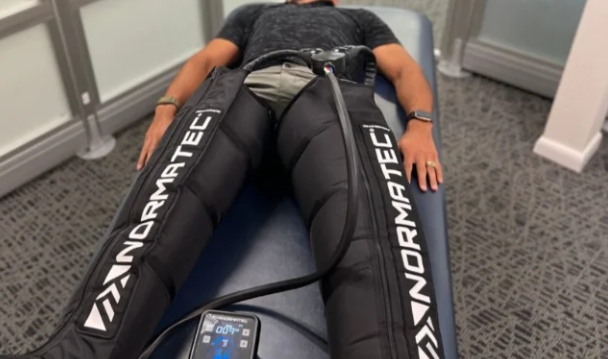 NormaTec compression recovery boots in use on a treatment bed at RegenSuites Basingstoke